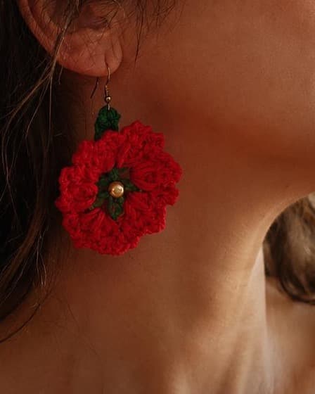Brincos Papoila: flor de crochê vermelha com folhas verdes e conta dourada ao centro